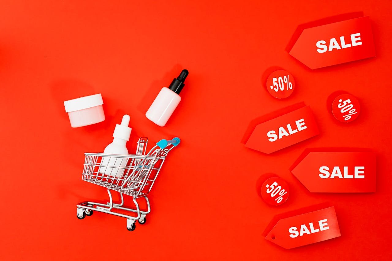 Skincare items in mini cart with sale tags on red background. Perfect for Black Friday ads.