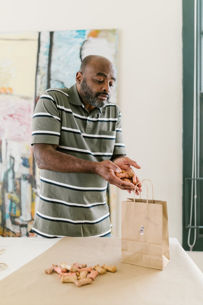 Man prepares handcrafted candles for packaging in a creative workspace, showcasing entrepreneurship.